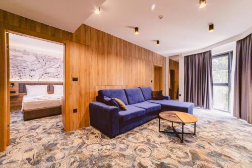 sala de estar con sofá azul y cama en Hotel Boutique Anoma, en Sarajevo