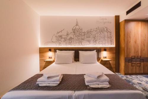 a bedroom with a bed with towels on it at Hotel Boutique Anoma in Sarajevo