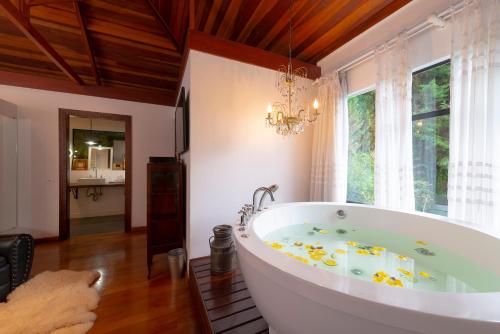 a large bath tub in a room with a window at Alma Hotel in Campos do Jordão