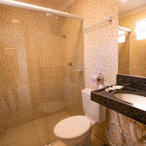 a bathroom with a shower and a toilet and a sink at Pousada Villa Costeira in Maragogi