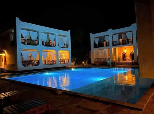 a large swimming pool in front of a building at night at Kilili Baharini Resort & Spa in Malindi