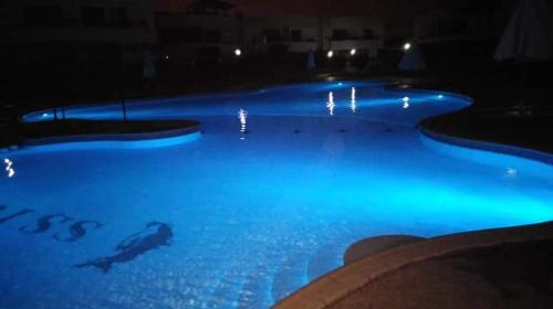 une piscine la nuit avec des lumières bleues dans l'établissement One bed in Criss resort Naama bay, à Charm el-Cheikh