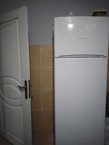 een witte koelkast in een keuken naast een deur bij Tuzla apart in Güzeltepe
