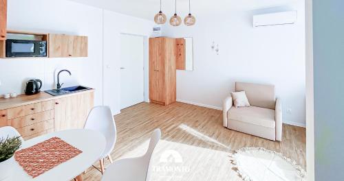 a kitchen and a dining room with a table and chairs at Tramonto Apartments Zator Przeciszów in Zator