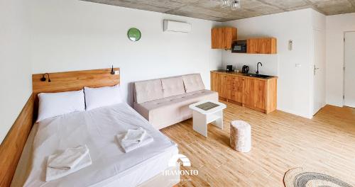 a bedroom with a bed and a couch in it at Tramonto Apartments Zator Przeciszów in Zator