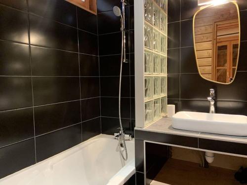 a bathroom with a sink and a tub and a mirror at Alpe d'Huez Houses - Chalet Justine - Duplex for up to 15 people amazing location in L'Alpe-d'Huez