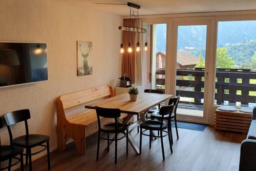a dining room with a wooden table and chairs at Ideal für gemütliche Ski-, Wander-, und Bergferien in Disentis