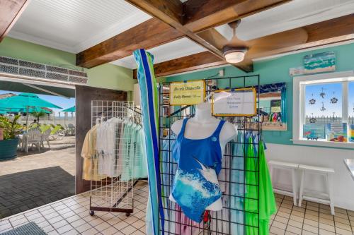 una tienda frente con una tabla de surf y un maniquí en A Wave From it All en Key Colony Beach