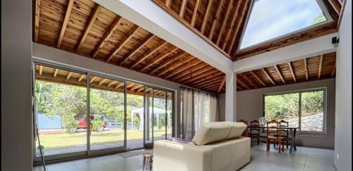 a living room with a vaulted ceiling and large windows at Villa Magnolia in Rabo de Peixe
