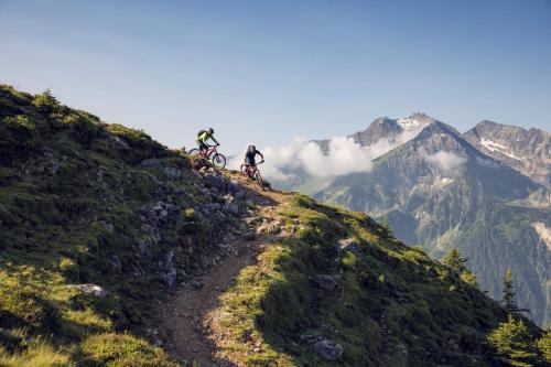 two people riding bikes on a mountain trail at ZWEITE HEIMAT - Alpine Garden Retreat in Zillertal, presented by AlpenLuxus in Fügen