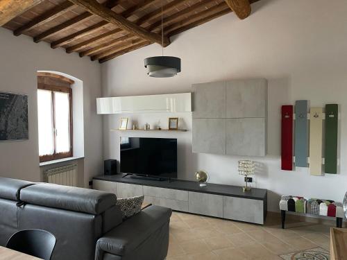 a living room with a couch and a television at La Casa in Castello in Ambra