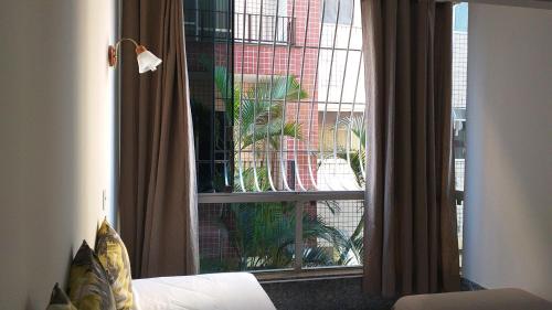 um quarto com uma janela com vista para um edifício em Apartamento a 500 metros da Praia doForte em Cabo Frio