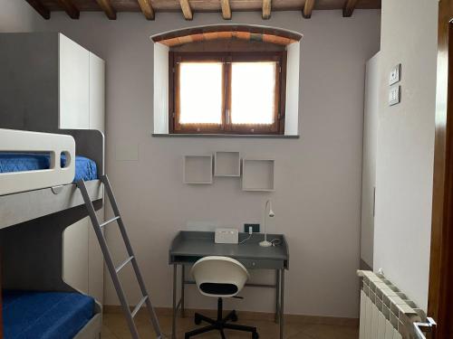 a bedroom with a desk and a bunk bed at La Casa in Castello in Ambra