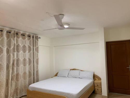 1 dormitorio con 1 cama y ventilador de techo en Two Bedroom Space Near KNUST & CCC, en Kumasi