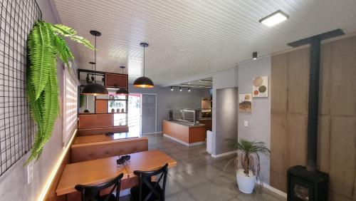 a dining room with a table and chairs and a kitchen at Reserva Guimarães in Cambara do Sul