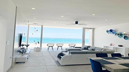 a living room with a couch and a view of the beach at The Perfect Spot! House Sea Esta Villa by Kivoya in Playa Encanto