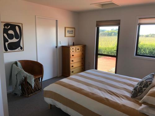 a bedroom with a bed and a dresser and a window at Ryland Estate Guest Apartment in Kaituna