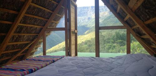 Ce lit se trouve dans un dortoir doté d'une grande fenêtre. dans l'établissement Gocta Dulce Hogar, à Cocachimba