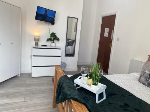 a living room with a bed and a tv on the wall at De Luxe Aparthotel in Leicester