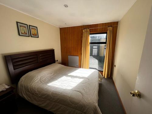 - une chambre avec un grand lit et une fenêtre dans l'établissement Cabaña Curaquilla - Arauco, à Arauco