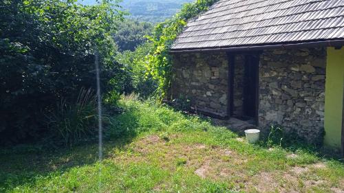 a stone building next to a stone wall at Vidiecky domček na samote in Horný Tisovník