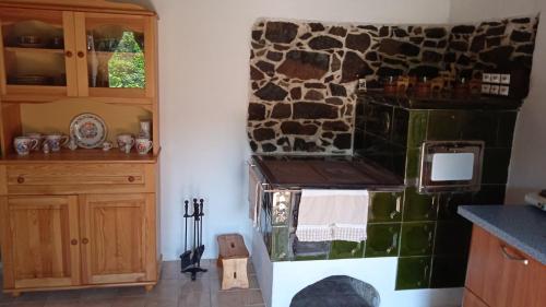 a kitchen with a stone wall and a stove at Vidiecky domček na samote 