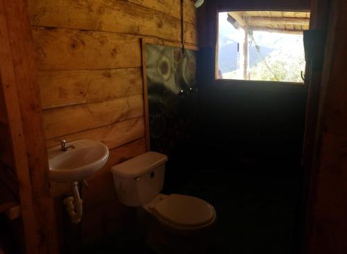 een badkamer met een wastafel en een toilet en een raam bij Gocta Dulce Hogar in Cocachimba