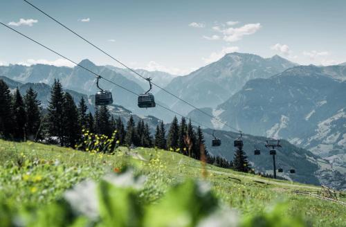 a ski lift on a hill with mountains in the background at ISANORA - Garden Apartment with Private Whirlpool in Zillertal, presented by AlpenLuxus in Fügen