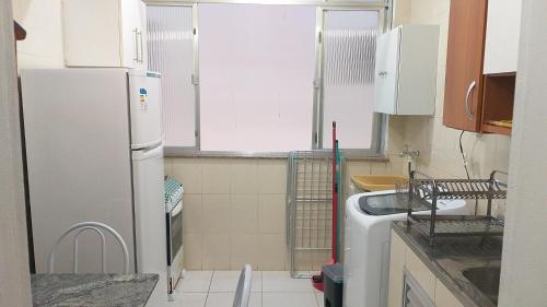 uma pequena cozinha com um frigorífico e um lavatório em Apartamento a 500 metros da Praia doForte em Cabo Frio