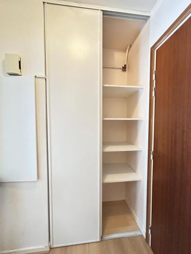 a closet with a white door and shelves at Les 6 reflets du lac in Torcy