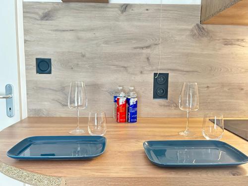 a kitchen counter with two wine glasses and bottles at Les 6 reflets du lac in Torcy