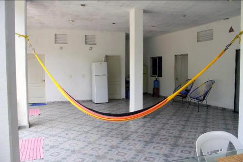 uma rede amarela e laranja num quarto em Chentes Place em Barra de la Cruz