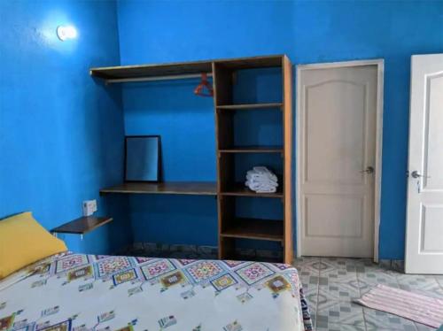 um quarto com uma cama e uma parede azul em Chentes Place em Barra de la Cruz