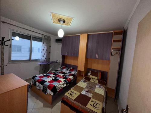 ein kleines Zimmer mit 2 Betten und einer Küche in der Unterkunft Holiday Apartment in Lezha
