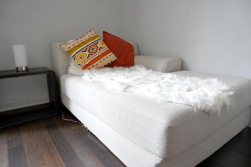 a white couch with pillows on top of it at Résidence Notre Dame in Châtellerault