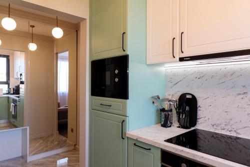 a kitchen with green cabinets and a counter top at Luxurious Apartment, Best View in Timişoara