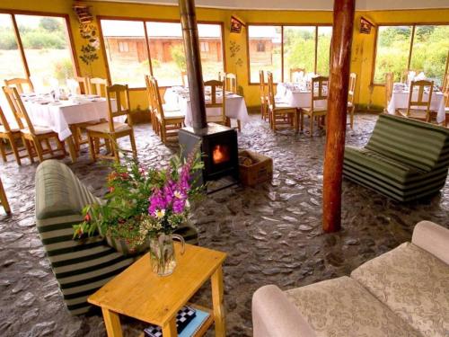 托雷斯德爾潘恩的住宿－Hostería Monte Balmaceda，一间带壁炉和桌椅的餐厅