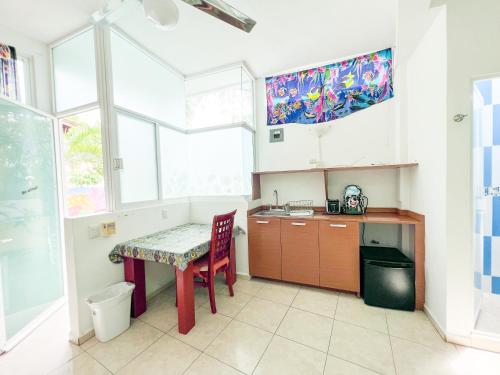 a kitchen with a table and a sink and a window at ITH Sayulita Amazing Surf Hostel in Sayulita