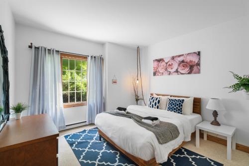 a bedroom with two beds and a window at Les Falaises Tremblant - Ski Inout Condo W2bdrs in Mont-Tremblant
