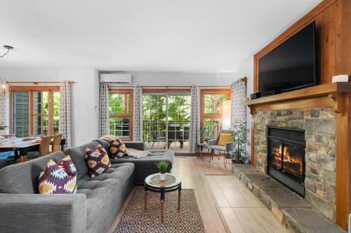 a living room with a couch and a fireplace at Les Falaises Tremblant - Ski Inout Condo W2bdrs in Mont-Tremblant