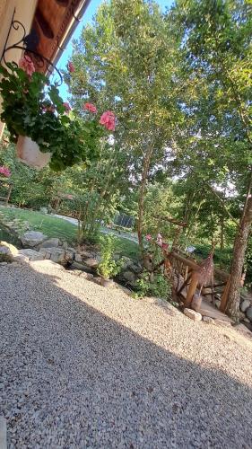 a garden with pink flowers and trees and gravel at Vis Împlinit in Cîrţişoara