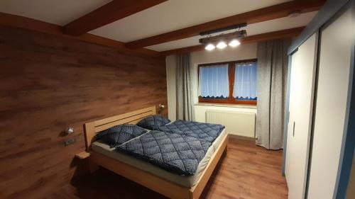 um quarto com uma cama num quarto com uma janela em Apartmán Pavel em Tux