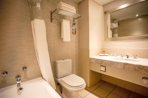 a bathroom with a toilet and a sink at Garden Court Kimberley in Kimberley