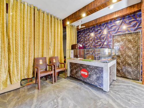un vestíbulo con 2 sillas y un mostrador con ventana en Super OYO Flagship Hotel R.m Havel en Kota