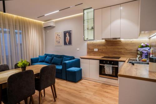 a kitchen and living room with a blue couch and a table at 2BR at Café Flora - Skanderbeg Square Area in Tirana