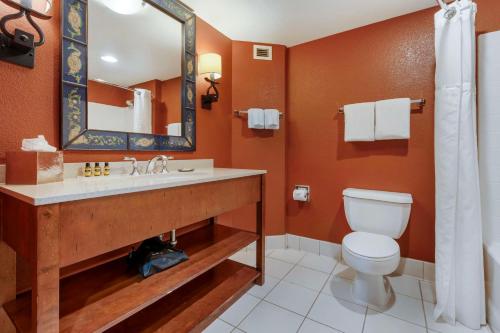 a bathroom with a toilet and a sink and a mirror at Best Western Plus Boomtown Casino Hotel in Reno