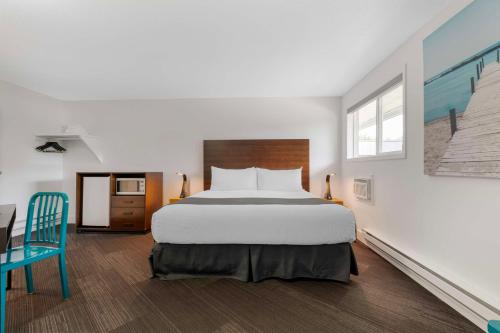 a bedroom with a large bed and a blue chair at Stoke Hotel SureStay Collection by Best Western in Revelstoke