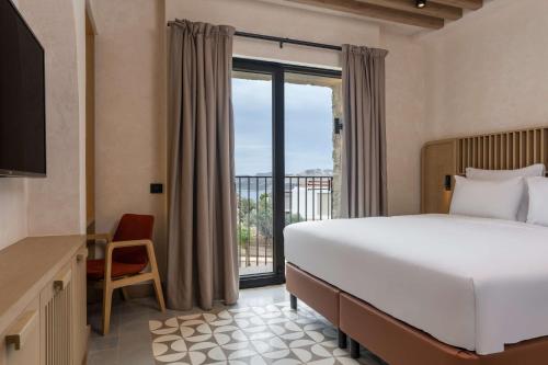 a hotel room with a bed and a balcony at Radisson Blu Hotel, Kas in Kaş