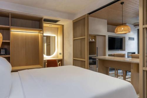 a hotel room with a white bed and a kitchen at Radisson Blu Hotel, Kas in Kas