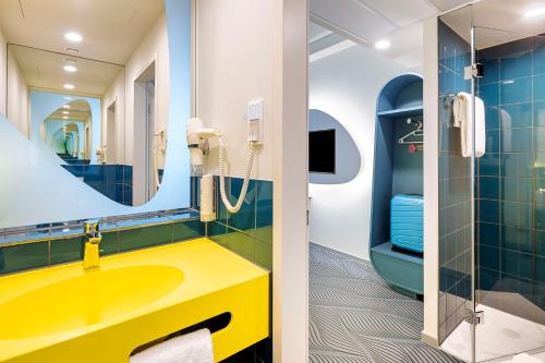 a bathroom with a yellow sink and a mirror at prizeotel Dortmund-City in Dortmund